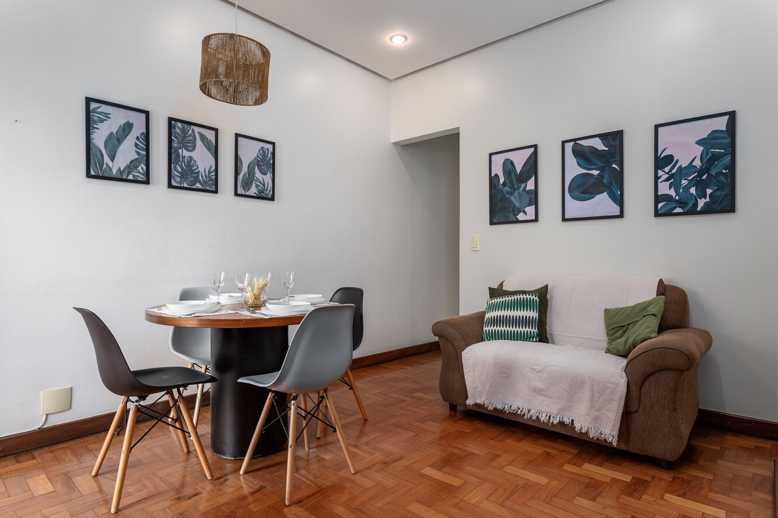 Un espace de salle à manger moderne avec une table ronde, des chaises et un luminaire suspendu.