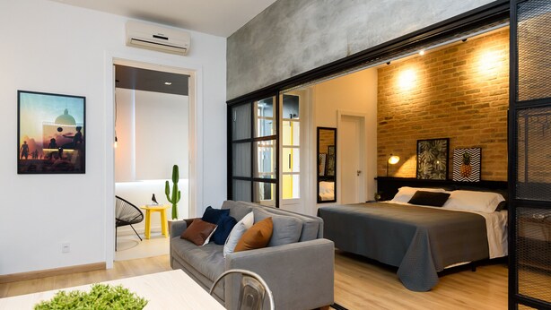 Un interior moderno con un sofá, una cama y un comedor.