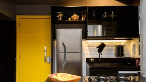 Una cocina moderna con una puerta amarilla, electrodomésticos de acero inoxidable y una estufa a gas.