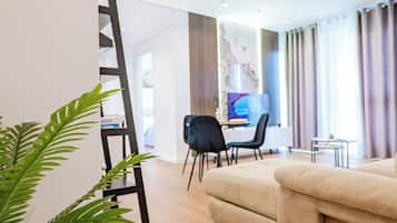 Apartamento Deluxe | Zona de estar | Smart TV de 42 pulgadas con canales por cable