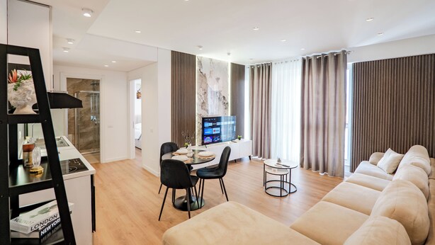Un salon moderne comprenant un canapé, un coin repas et un téléviseur.