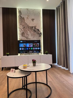 Deluxe-Apartment, Stadtblick | Wohnbereich | 42-Zoll-Smart-TV mit Kabelempfang