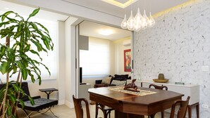 A dining area with a wooden table, chairs, and a potted plant.