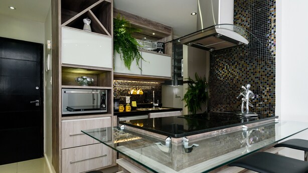 Una cocina moderna con una isla de vidrio, electrodomésticos de acero inoxidable y un salpicadero decorativo.