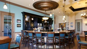 A bar area with a round table, multiple chairs, and a bar counter with bottles.