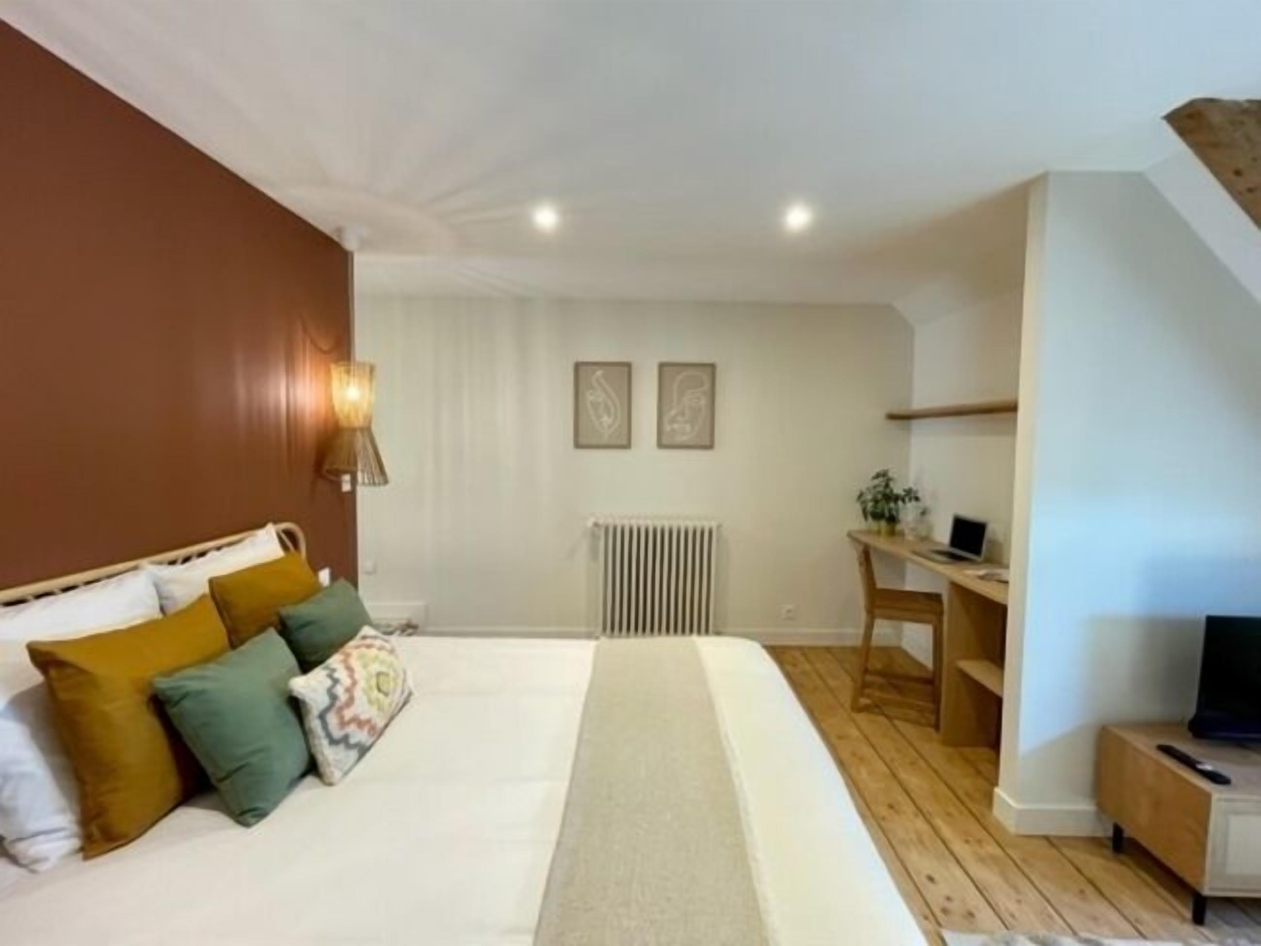 Une chambre à coucher avec un lit, un bureau et un radiateur.