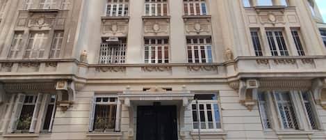 A large, historic building with multiple floors and a central entrance.
