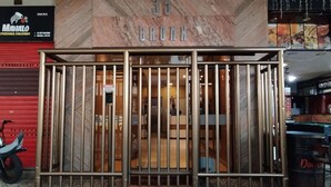 A building entrance with a metal gate, a tiled floor, and a sign above the gate that reads "35 BRONX".