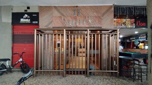 A building entrance with a metal gate, a red shutter, and a sign for '35 BRONX'.