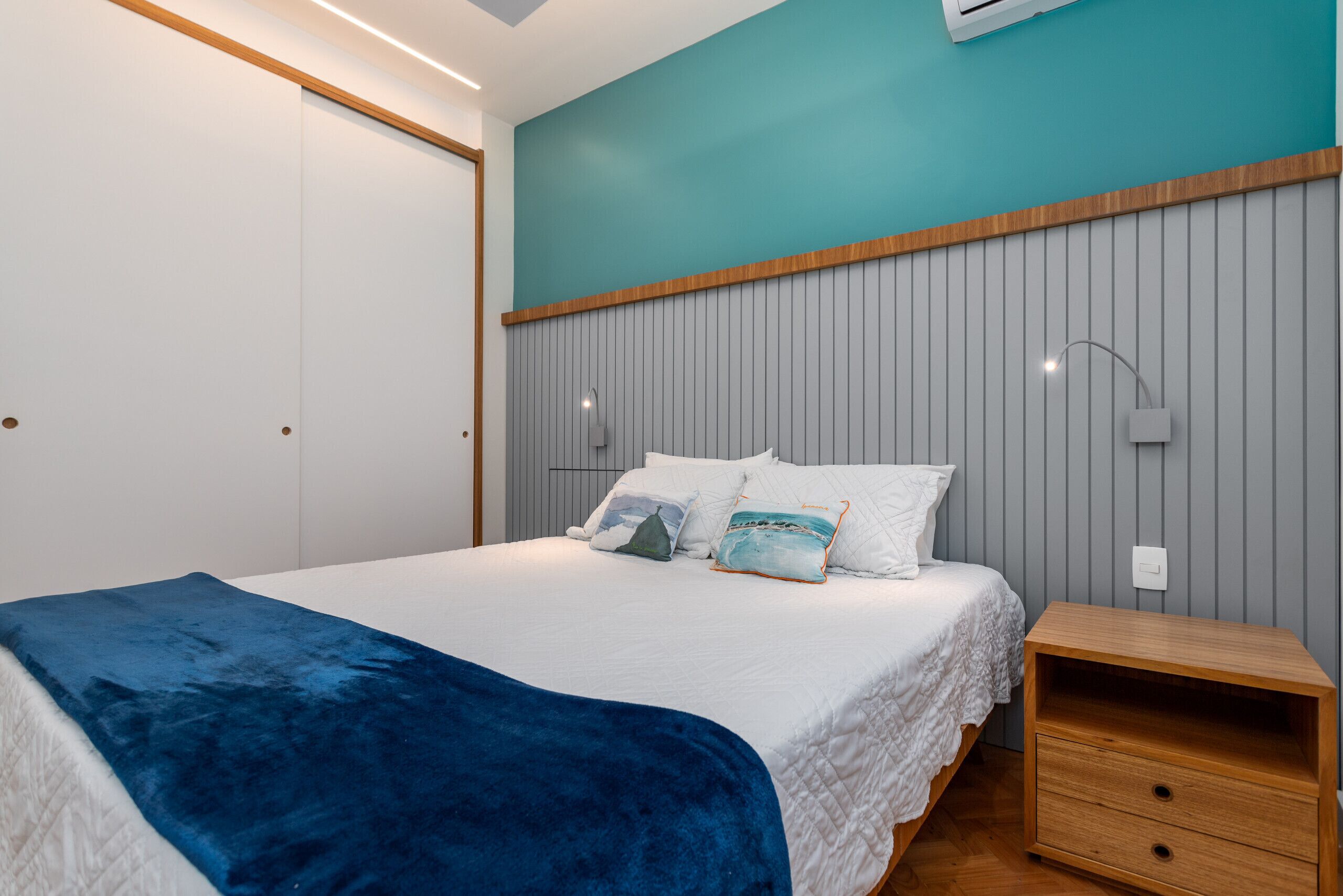 A bedroom with a bed, a bedside table, and a wardrobe.