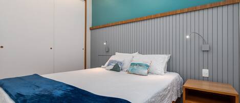 A bedroom with a bed, a bedside table, and a wardrobe.