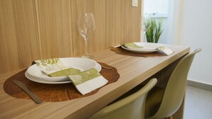 Una mesa de comedor dispuesta con platos, una copa de vino y una servilleta.