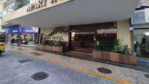 Un edificio con un letrero que dice "APART HOTEL" y una tienda de "Ortobom" al otro lado de la calle.