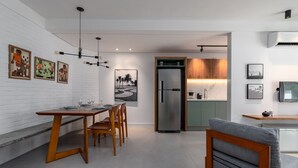 Una cocina moderna con refrigerador integrado, armarios de madera y un comedor con mesa y sillas.