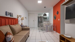 A modern living room with a sofa, a dining table with chairs, and a kitchen area in the background. - Beauty at Recreio | For 5 peopple | SA201 (Rio de Janeiro)
