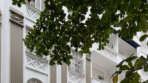 Un bâtiment blanc doté de nombreux balcons et de fenêtres en arc de cercle. On peut y lire une enseigne indiquant « South Park Residence ».