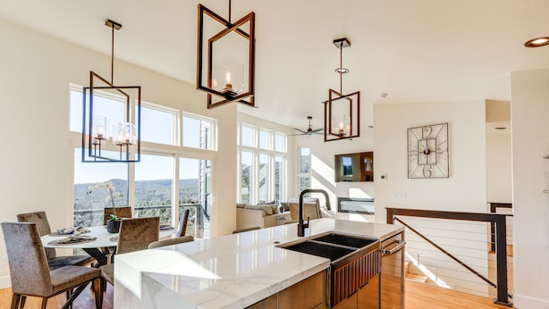 A spacious kitchen with a large island, modern pendant lights, and a view of the outdoors. - Hot Tub & Panoramic Mtn Views: Pine Retreat! (Pine)