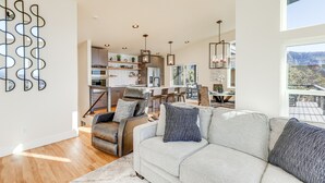 A spacious living area with a sofa, a leather chair, and a dining table. - Hot Tub & Panoramic Mtn Views: Pine Retreat! (Pine)