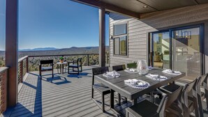 A deck with a table and chairs, overlooking a mountainous landscape. - Hot Tub & Panoramic Mtn Views: Pine Retreat! (Pine)