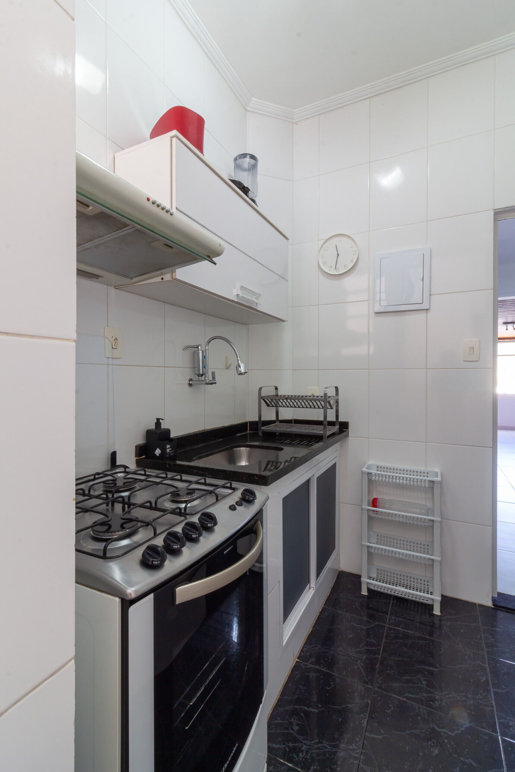 A kitchen with a gas stove, oven, and a sink.
