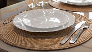 A dining table set with plates, cutlery, and glasses, with a view of a sofa and a painting in the background. - 3 minutes from Copacabana beach | NSC904 (Rio de Janeiro)