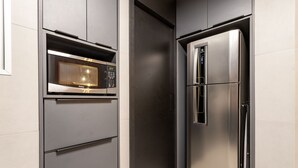 A kitchen with a built-in microwave and a stainless steel refrigerator. - 5 minutes from Leblon Beach | AP302 (Rio de Janeiro)