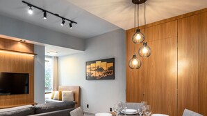A modern dining area with a round table, grey upholstered chairs, and a wooden cabinet. - 5 minutes from Leblon Beach | AP302 (Rio de Janeiro)
