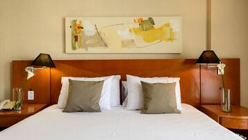 Hotelkamer met een groot bed, twee nachtkastjes, een schilderij aan de muur en een telefoon op een van de nachtkastjes.