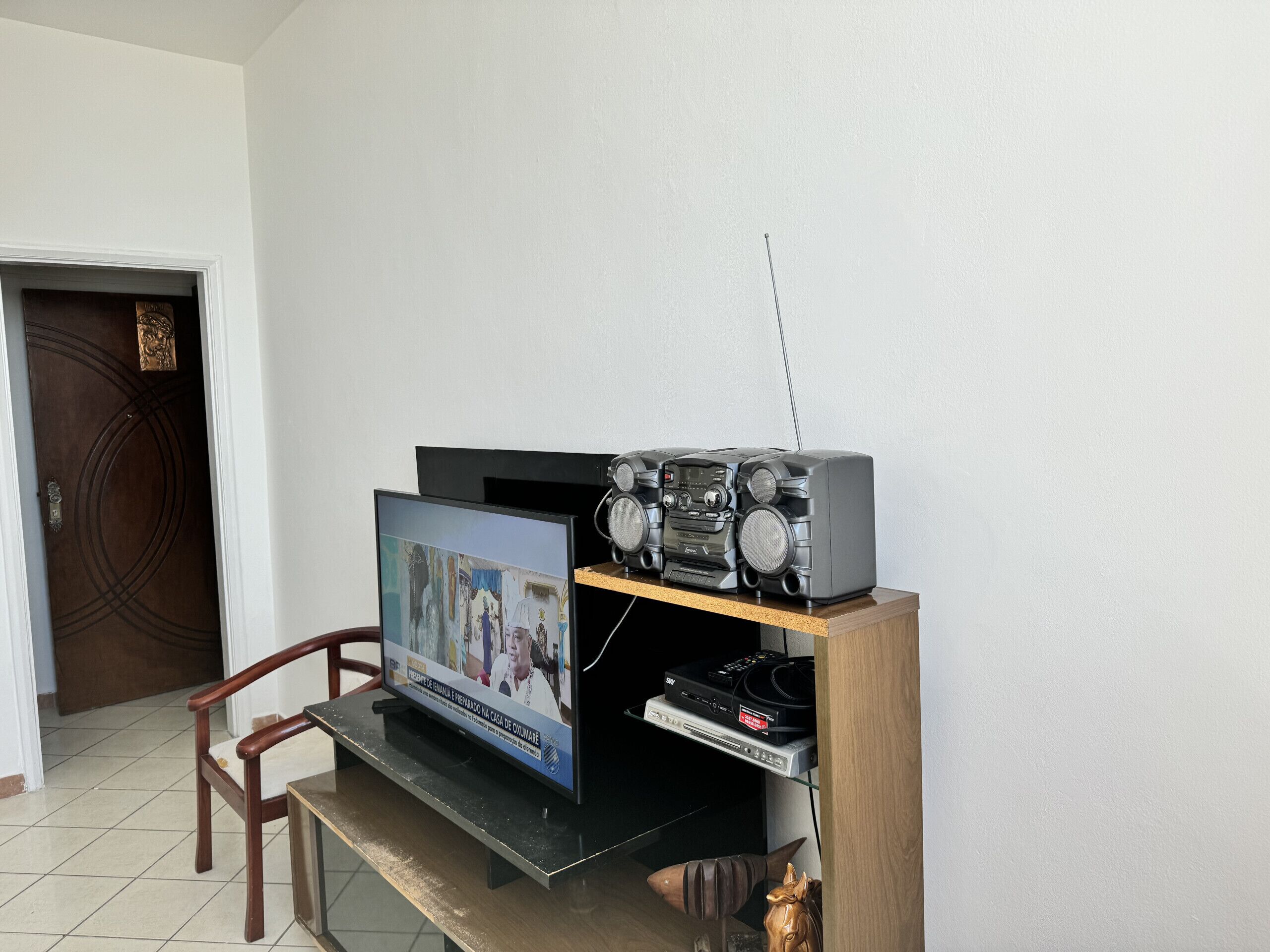 Een televisie op een houten standaard, met een geluidsinstallatie erop.