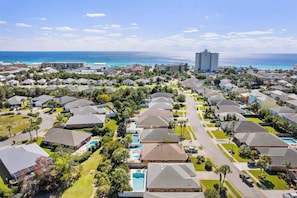 A residential area with houses, a swimming pool, and a view of the ocean.