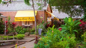 A brick building with a yellow awning labeled "Devon House Baker." - Camperdown Place (Kingston)