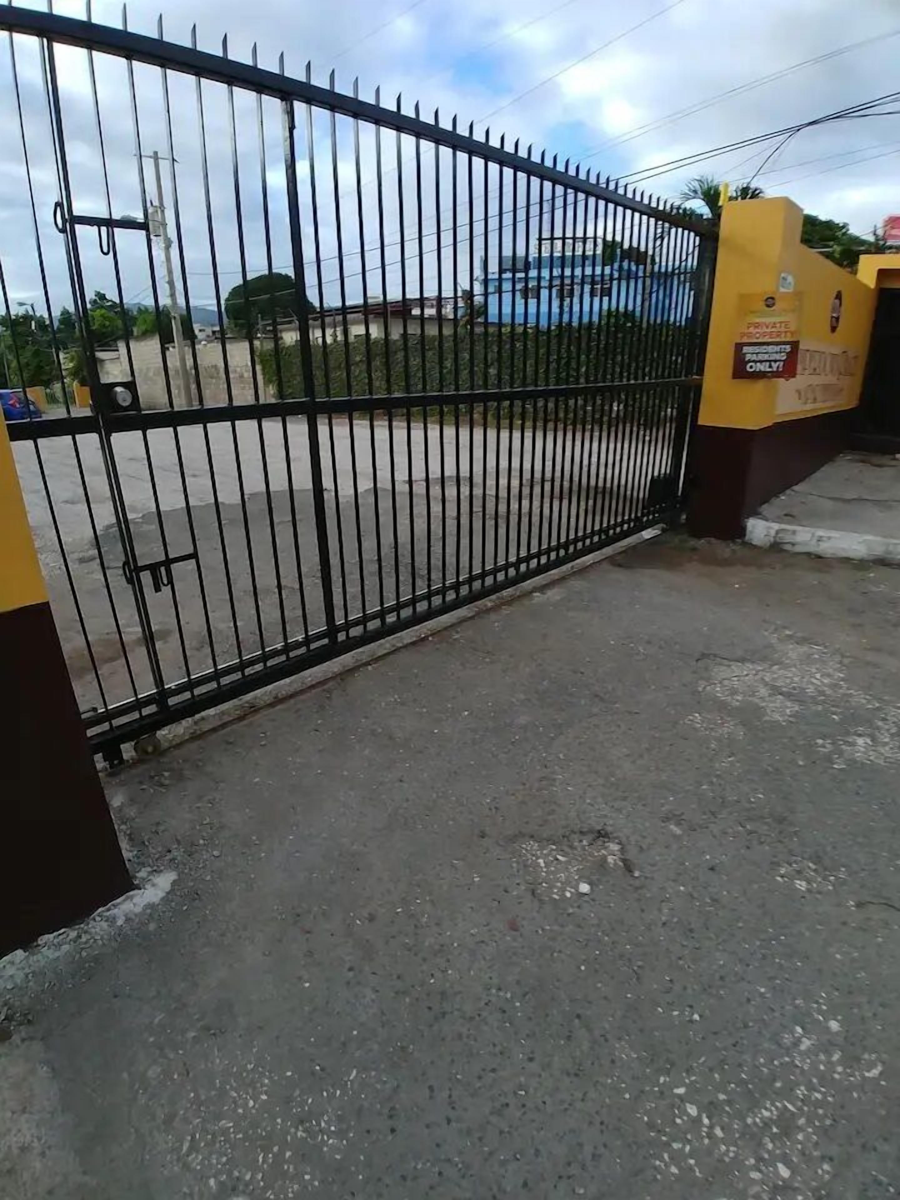 A gated entrance with a metal fence and a yellow sign indicating private property.