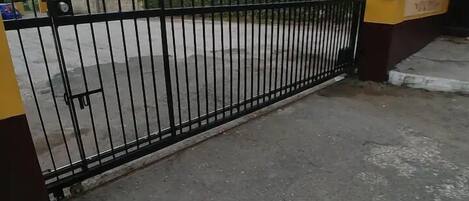 A gated entrance with a metal fence and a yellow sign indicating private property.