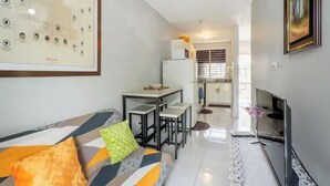 A modern living room with a sofa, a TV, and a framed picture on the wall. - Camperdown Place (Kingston)
