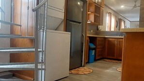 Una cocina moderna con armarios de madera, horno empotrado y refrigerador de acero inoxidable.