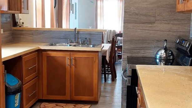 Una cocina moderna con armarios de madera, encimera de granito y una isla central.