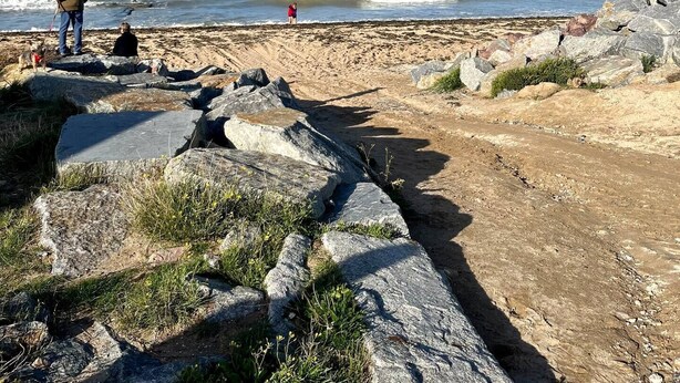 Ein felsiger Strand unter blauem Himmel.