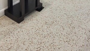 Una habitación con un mueble negro para el televisor, una planta en maceta y una cortina.