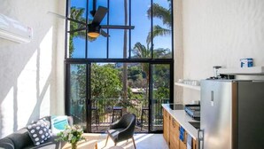 A modern kitchen with large windows, a ceiling fan, and a view of palm trees. - Tranquility at La Isla Brisas 2 (Sayulita)
