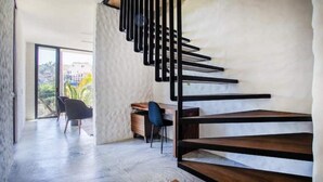 Ein modernes Interieur mit Treppe, Schreibtisch und Stuhl.