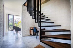 Stylish space with a minimalist staircase, desk, and large window.