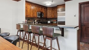 A kitchen with wooden cabinets, a stainless steel refrigerator, a microwave, and a bar area with stools. - Spacious 2BD + Den, Ski In Out
In the Heart of Beaver Creek Village
Pool jacuzzi (Beaver Creek)