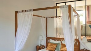 A four-poster bed with a canopy, wooden headboard, and a bedside table with a lamp. - 靠近巴黎戴高乐机场，国际展览中心，法国体育场，迪斯尼乐园，花园365平面，200平面别墅，可容纳14个人，五间卧室，三个浴室，花园可烤肉，大餐桌和阳伞，三个秋千 (Aulnay-sous-Bois)