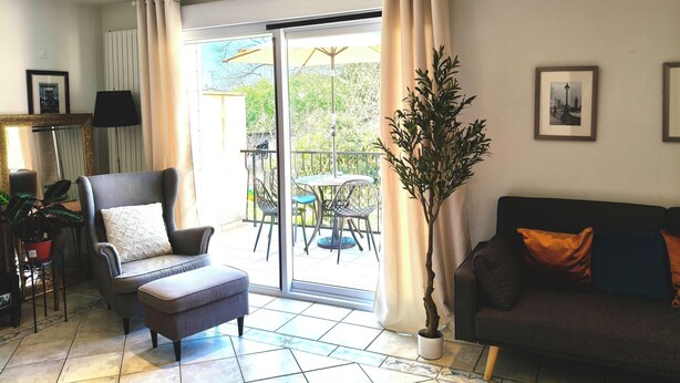 A living room with a sofa, armchair, and a potted plant. - 靠近巴黎戴高乐机场，国际展览中心，法国体育场，迪斯尼乐园，花园365平面，200平面别墅，可容纳14个人，五间卧室，三个浴室，花园可烤肉，大餐桌和阳伞，三个秋千 (Aulnay-sous-Bois)