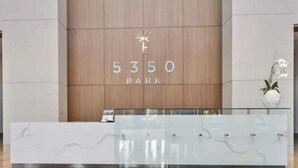 A reception desk with a wooden backdrop and the number 5350 prominently displayed. - Stylish 2BR Condo. Walk to Restaurants & Shops (Doral)