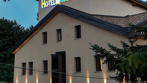 Un hotel llamado "Hotel Caliguri" con estilo arquitectónico moderno, que presenta un techo plano y ventanas distribuidas uniformemente.