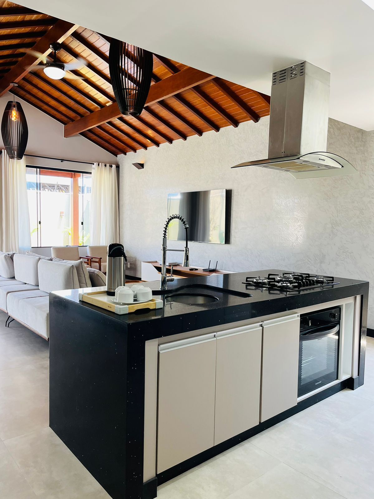 A modern kitchen with a central island, stainless steel appliances, and a ceiling fan.