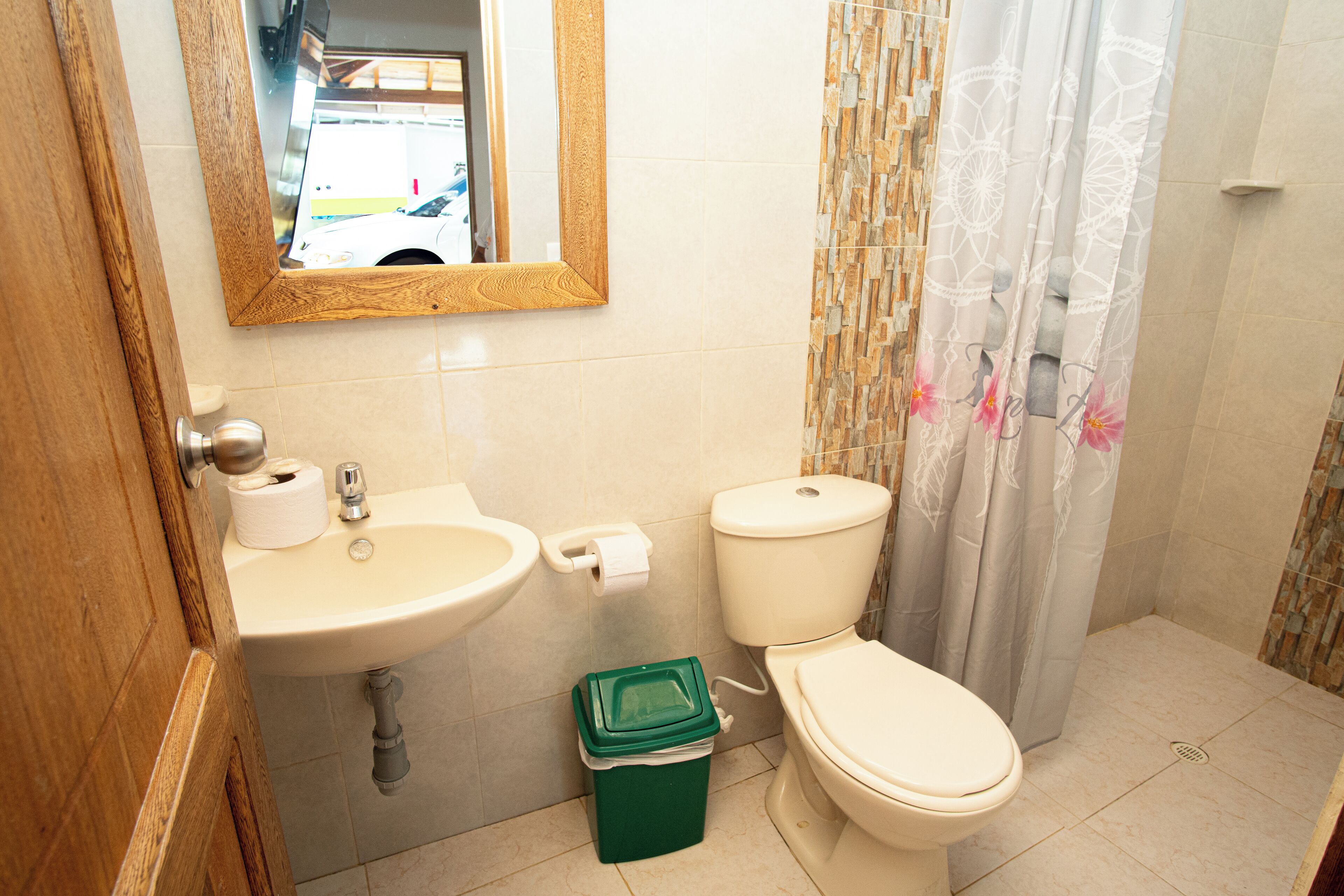 Un baño con lavabo, inodoro y cortina de ducha.