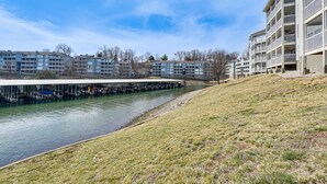 Vista del río de un moderno complejo de apartamentos con un paseo techado a lo largo del agua.