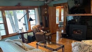 Una sala de estar acogedora con un sofá a rayas, una mesa de centro de madera y una chimenea.